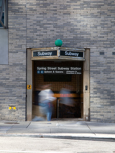 Entrance to Spring Street Subway station, with blurred figure walking past